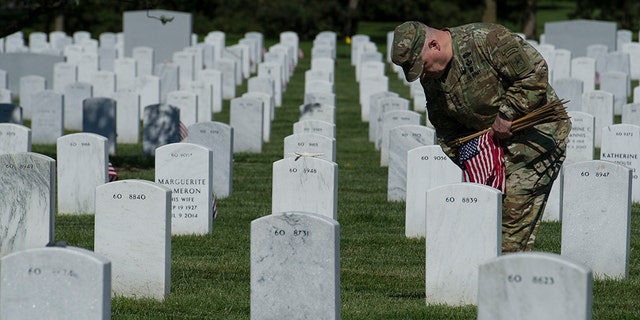 Army Chief of Staff Gen. Mark Alexander Milley places flags at gravesite as the Army 3d U.S. Infantry Regiment, The Old Guard, honor the nation's fallen military heroes during its annual Flags In ceremony at Arlington National Cemetery, May 24, 2018. Milley will join President Biden as he gives Memorial Day remarks at the cemetery in honor of Memorial Day Monday. (AP Photo/Cliff Owen)