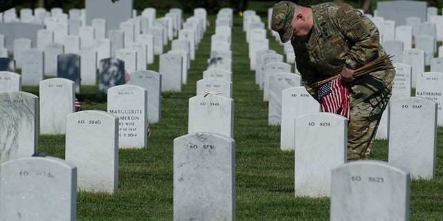 Army Chief of Staff Gen. Mark Alexander Milley places flags at gravesite as the Army 3d U.S. Infantry Regiment, The Old Guard, honor the nation's fallen military heroes during its annual Flags In ceremony at Arlington National Cemetery, May 24, 2018. Milley will join President Biden as he gives Memorial Day remarks at the cemetery in honor of Memorial Day Monday. (AP Photo/Cliff Owen)