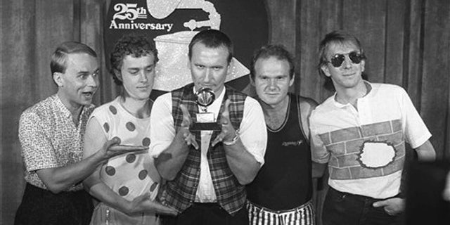 Feb. 22, 1983: In this file photo, members of 'Men at Work' from left, Greg Ham, Ron Strykert, Colin Hay, Jerry Speiser and John Rees, pose with their Grammy for best new artist at the awards show in Los Angeles.