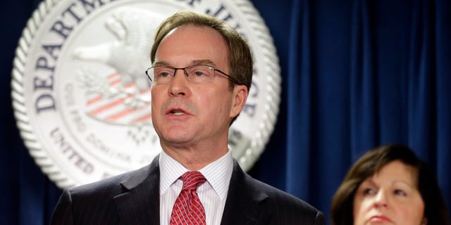 Dec. 17, 2014: Michigan Attorney General Bill Schuette speaks after U.S. Attorney Carmen Ortiz, right, announced indictments of 14 owners and employees from the New England Compounding Center
