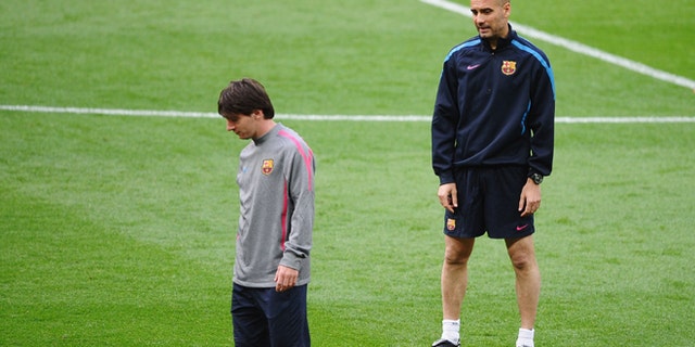 Lionel Messi of FC Barcelona (L) walks away from Josep "Pep" Guardiola, then-manager of FC Barcelona looks on during training session at Wembley Stadium in London on May 27, 2011. The two will face off in a game between Barca and Guardiola's new team, Bayern Munich. (Photo by Laurence Griffiths/Getty Images)