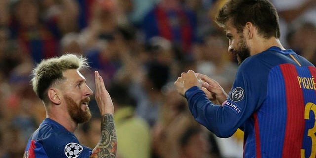 Barcelona's Lionel Messi, left, celebrates scoring his side's 5th goal and his hat trick with Gerard Pique during a Champions League, Group C soccer match between Barcelona and Celtic, at the Camp Nou stadium in Barcelona, Spain, Tuesday, Sept. 13, 2016. (AP Photo/Emilio Morenatti)