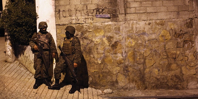 ACAPULCO, MEXICO - MARCH 03: Mexican army soldiers stand guard near a suspected drug-related murder site March 3, 2012 in Acapulco, Mexico. A forensics team excavated five corpses from the floor of an abandoned house. Officials said the five victims were apparently buried alive in concrete. Drug violence has surged in the coastal resort in the last year, making Acapulco the second most deadly city in Mexico after Juarez. One of Mexico's top tourist destinations, Acapulco has suffered a drop in business, especially from foreign tourists, due to the violence. Toursim accounts for about 70 percent of the economy of Acapulco's state of Guerrero and 9 percent of Mexico's economy. (Photo by John Moore/Getty Images)