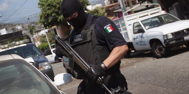 ACAPULCO, MEXICO - MARCH 01: A Mexican federal policeman inspects an abandoned car on March 1, 2012 in Acapulco, Mexico. Stolen vehicles used by drug gangs are often found abandoned throughout the city. Drug violence surged in the coastal resort last year, making Acapulco the second most deadly city in Mexico after Juarez. One of Mexico's top tourist destinations, Acapulco has suffered a drop in business, especially from foreign tourists, due to reports of the violence. Toursim accounts for some 9 percent of Mexico's economy and about 70 percent of the output of Acapulco's state of Guerrero. (Photo by John Moore/Getty Images)