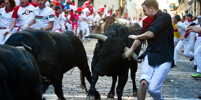 PAMPLONA, SPAIN - JULY 12: Revelers run with bulls from the Victoriano del Rio ranch along Estafeta street on the sixth day of the San Fermin running-of-the-bulls on July 12, 2012 in Pamplona, Spain. Pamplona's famous Fiesta de San Fermin, which involves the running of the bulls through the historic heart of Pamplona for eight days starting July 7th, was made famous by the 1926 novel of U.S. writer Ernest Hemmingway called 'The Sun Also Rises.' (Photo by Jasper Juinen/Getty Images)