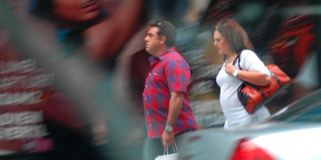In this August 2013 surveillance photo provided by the Drug Enforcement Administration, Francisco Salgado and his sister Alejandra walk on New York's Third Avenue in midtown Manhattan where authorities say they made multiple cash deposits at banks within a few blocks of each other as part of a Mexican cartel money-laundering scheme. Authorities say the pair entered seven different banks making cash deposits of just under $10,000, all from piles of drug money they were carrying in designer purses and shopping bags. (DEA via AP)