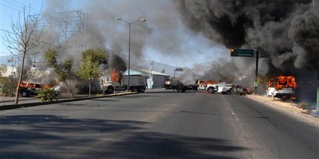 Dec. 9, 2010: Vehicles burn on a road leading to the city of Morelia, Mexico, after gunmen arrived at all five roads leading into the city, fired into the air and forced people from their vehicles.