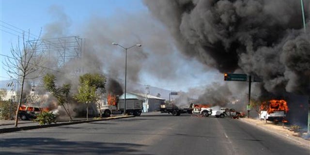 Dec. 9, 2010: Vehicles burn on a road leading to the city of Morelia, Mexico, after gunmen arrived at all five roads leading into the city, fired into the air and forced people from their vehicles.