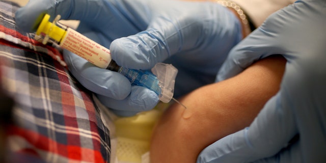 CORAL GABLES, FL - JANUARY 07: Pediatrician Dr. Amanda Porro M.D. delivers a flu vaccination to an infant's leg during his visit to the Miami Children's Hospital on January 7, 2015 in Coral Gables, Florida. The Centers for Disease Control and Prevention announced that in the United States the virus that causes the flu is particularly bad this year and has hit most parts of the United States, with 43 states experiencing "widespread" flu activity and six others reporting "regional" flu activity. (Photo by Joe Raedle/Getty Images)