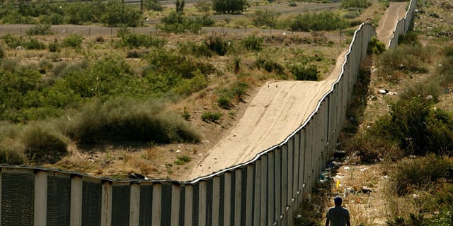 CIUDAD JUAREZ, CHIHUAHUA - JUNE 29: A man walks along the border fence between the U.S. and Mexico on June 29, 2007 in the Anapra area of Ciudad Juarez, Mexico. This area is a popular crossing spot for immigrants to ilegally cross into the United States because houses are close to the border on the south side and the highway is close to the north side. (Photo by Chip Somodevilla/Getty Images)