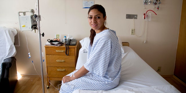 Karla Sanchez San Martin, one of Mexico's few female bullfighters, poses for a portrait in her hospital bed in Mexico City, Tuesday, Dec. 30, 2014. Sanchez, who goes by the name Karla de los Angeles as a bullfighter, suffered a pair of gashes to the thigh and buttock when she was gored twice by a bull on Sunday but says she's determined to return to the ring by mid-January, two days after she and several others were gored by what she described as a "very smart" bull. (AP Photo/Eduardo Verdugo)