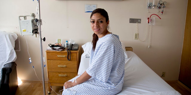 Karla Sanchez San Martin, one of Mexico's few female bullfighters, poses for a portrait in her hospital bed in Mexico City, Tuesday, Dec. 30, 2014. Sanchez, who goes by the name Karla de los Angeles as a bullfighter, suffered a pair of gashes to the thigh and buttock when she was gored twice by a bull on Sunday but says she's determined to return to the ring by mid-January, two days after she and several others were gored by what she described as a "very smart" bull. (AP Photo/Eduardo Verdugo)