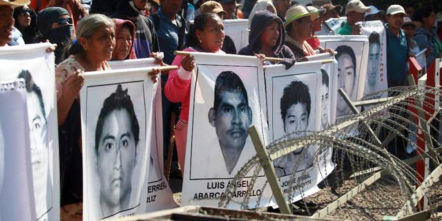 FILE - In this Dec. 18, 2014 file photo, relatives of missing students protest in front of the entrance to the 27th Infantry Battalion base in Iguala, Mexico. Mexican authorities announced Tuesday, Jan. 13, 2015, that the parents of the 43 missing students can enter army bases to search for their sons, but say there is no evidence the army was involved in their disappearance. (AP Photo/Felix Marquez, File)