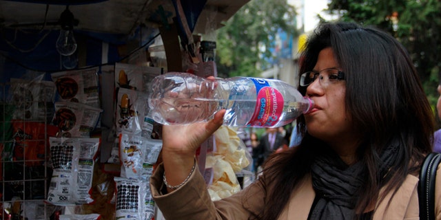 In this Jan. 9, 2014 photo, a woman drinks bottled water in Mexico City. Bad tap water accounts in part for Mexico being the highest consumer of bottled water and sweetened drinks. A law recently approved by Mexico Cityâs legislators will require all restaurants to install filters, offering patrons free, apparently drinkable potable water that wonât lead to stomach problems and other ailments. With an obesity epidemic looming nationwide, the cityâs health department decided to back the water initiative. (AP Photo/Marco Ugarte)