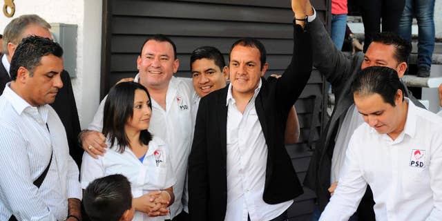 FILE - In this Jan. 22, 2015 file photo, professional soccer player Cuauhtemoc Blanco raises his arm after pre-registering to run for mayor in Cuernavaca, Mexico. (AP Photo/Tony Rivera, File)
