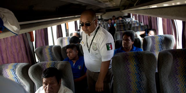FILE - In this Aug. 27, 2014, file photo, an immigration official checks a bus for Central American migrants, at a roadblock north of Arriaga, Chiapas state, Mexico. According to data from Mexicos National Immigration Institute, Mexico has deported 79 percent more Central Americans in the first four months of 2015 than it did during the same period a year earlier. (AP Photo/Rebecca Blackwell, File)