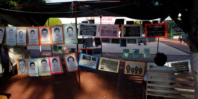 In this Oct. 1, 2015 photo, a man sits next to a permanent installation memorializing the 43 missing students, outside of the municipal palace in the city of Iguala, Mexico. The disappearance of 43 students at the hands of Iguala police on Sept. 26, 2014 began to unveil the scope of police involvement in Mexicos nearly 26,000 recorded disappearances. Amid national outrage over the students abduction, hundreds of families came forward to report their missing relatives, many of them also with the complicity of police. (AP Photo/Dario Lopez-Mills)