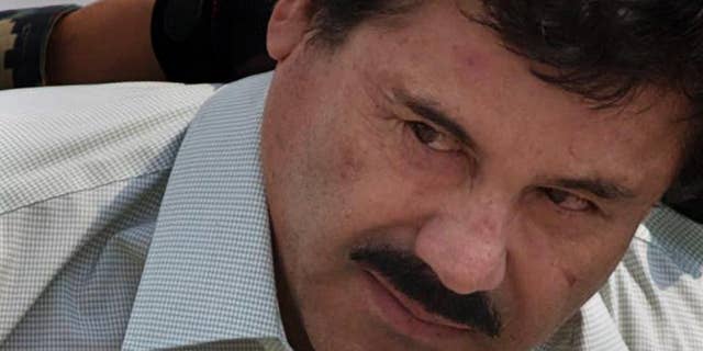 FILE - In this Feb. 22, 2014, file photo, Joaquin "El Chapo" Guzman is escorted to a helicopter in handcuffs by Mexican navy marines at a navy hanger in Mexico City. A judge in Mexico issued on Thursday, July 30, 2015, a provision warrant to detain Guzman based on an extradition request from the United States. Guzman also faces a host of Mexican charges following his July 11 escape through a tunnel from Mexico’s highest-security prison. (AP Photo/Eduardo Verdugo,File)