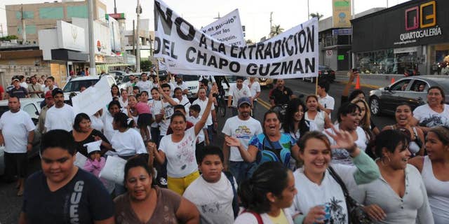 FILE - In this Feb. 26, 2014 file photo, people march in support of jailed drug boss Joaquin Guzman, "El Chapo," in the city of Culiacan, Mexico. Hundreds marched in the streets of the drug lord's bastion, demanding that Guzman be freed. Guzman, the one they called "shorty" because of his 5'6" frame grew up poor and had no formal education, would rise from a small-time Mexican marijuana producer to lead the world's most powerful drug cartel. (AP Photo/El Debate de Culiacan, Jonathan Telles, File)