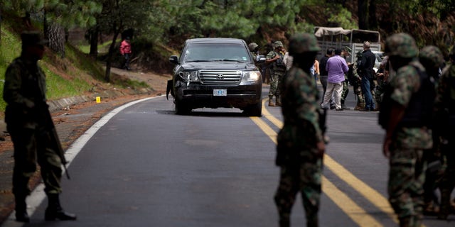 Military personal stand guard around an armored U.S. Embassy vehicle after it was attacked by unknown assailants on the highway leading to the city of Cuernavaca, near Tres Marias, Mexico, Friday, Aug. 24, 2012. Two U.S.  government employees were shot and wounded in an attack on their vehicle south of Mexico City on Friday, a law enforcement official said. (AP Photo/Alexandre Meneghini)