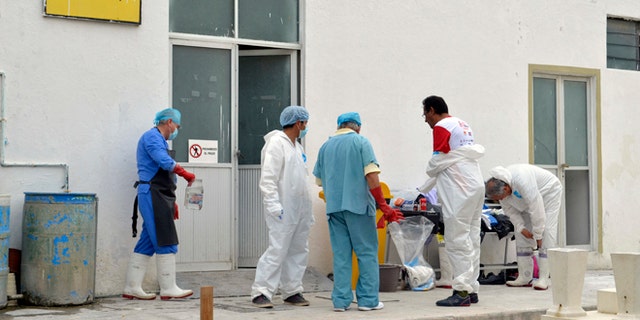 Forensic workers at a morgue inside the cemetery of the city of Tehuacan, Mexico, Saturday, June 11, 2016.