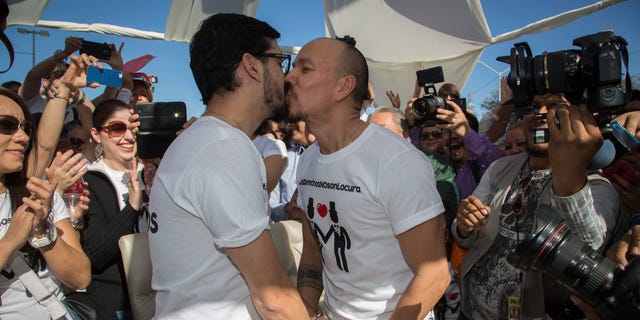 Victor Fernando Urias, left, and Victor Manuel Aguirre, kiss after they learned they were allowed to marry, during a protest outside of the municipal palace in the northern border city of Mexicali, Mexico, Saturday Jan., 17, 2015. The protest was held against Mexicali's mayor and other officials after blocking for a fourth time the gay couple from marrying in defiance of an order from Mexico's Supreme Court, the men's lawyer said. Hours later, the Mayor allowed the couple to marry. (AP Photo/Alex Cossio)