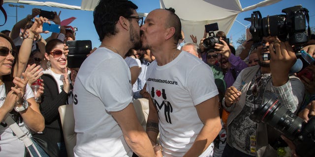 Victor Fernando Urias, left, and Victor Manuel Aguirre, kiss after they learned they were allowed to marry, during a protest outside of the municipal palace in the northern border city of Mexicali, Mexico, Saturday Jan., 17, 2015. The protest was held against Mexicali's mayor and other officials after blocking for a fourth time the gay couple from marrying in defiance of an order from Mexico's Supreme Court, the men's lawyer said. Hours later, the Mayor allowed the couple to marry. (AP Photo/Alex Cossio)