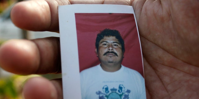 A relative of journalist Gregorio Jimenez holds a photo of him in Coatzacoalcos, Mexico.