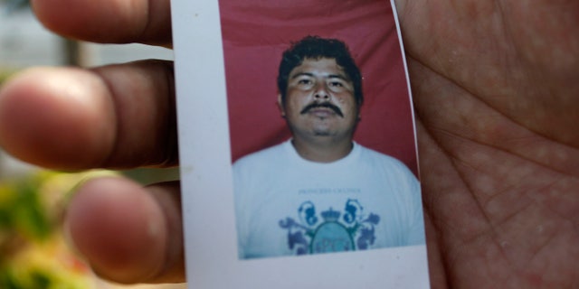 A relative of journalist Gregorio Jimenez holds a photo of him in Coatzacoalcos, Mexico.