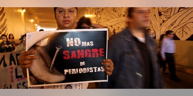 A man carrying a sign saying "No more blood of journalists" during a protest to demand justice in the Regina Martinez case