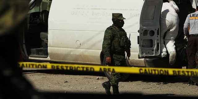 JUAREZ, MEXICO - MARCH 19: A Mexican soldier keeps guard near the site of a recent murder on March 19, 2010 in Juarez, Mexico. The border city of Juarez has been racked by violent drug-related crime, making it among the most dangerous cities in the world. As competing drug cartels fight over lucrative drug corridors along the U.S. border, the murder rate in Juarez has risen to 173 slayings for every 100,000 residents. President Felipe Calderon in 2009 disbanded the corrupt local police force and sent 10,000 soldiers to Juarez, but the violence has raged on. With a population of 1.3 million in Juarez, 2,600 died in drug-related violence last year and 500 so far this year, including two Americans who worked for the U.S. Consulate last weekend as they returned from a childrens party. (Photo by Spencer Platt/Getty Images)