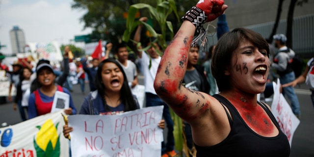Protestors chant during a march commemorating the anniversary of the Tlatelolco Massacre, in Mexico City, Sunday, Oct. 2, 2016. Every year Mexico marks the anniversary of the 1968 massacre where students and civilians were killed by the military and police.(AP Photo/Rebecca Blackwell)