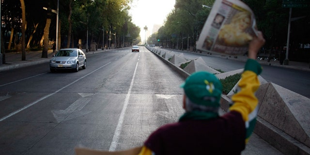 MEXICO CITY - MAY 01: A newspaper vendor has few sales as vehicle traffic is light due to the beginning of a national holiday and the government advising people to stay home in hopes of containing the swine flu on May 1, 2009 in Mexico City, Mexico. Cases of swine flu, the strain known as H1N1 virus, have been confirmed in nine countries, including Mexico, where at least 2,400 are believed to be infected, with the number of deaths attributed to the virus believed to be more than 150. The World Health Organization today raised the threat level to 'phase 5,' indicating a 'pandemic is imminent. (Photo by Joe Raedle/Getty Images)