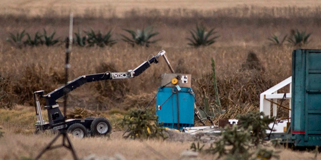 A robotic arm recovers radioactive cobalt-60 and deposits it in a safe container on a field in the town of Hueypoxtla, central Mexico, Tuesday Dec. 10, 2013.