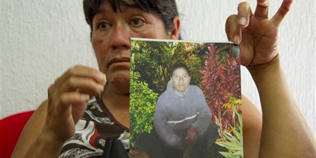Maria Rios Cueto, holds up a photo of her nephew, Ezequiel Cordoba Rios in Tuxtla Gutierrez, Mexico, Thursday Feb. 6, 2014. Cordoba was the Mexican fisherman who died during a reported 13-month sea odyssey with Jose Salvador Alvarenga. Alvarenga, a Salvadoran fisherman, said Ezequiel died early in the voyage and that he tossed Cordoba's body overboard, while he survived by eating fish, turtles and birds. (AP Photo/Moyses Zuniga)