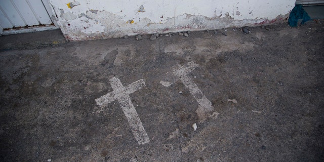 In this Aug. 19, 2015 photo, painted crosses mark the site where two college students were killed and 43 more kidnapped, in Iguala, Mexico on Sept. 26, 2014. According to a federal investigation, the students were taken by police and then handed over to a local drug gang that allegedly killed them and burned the bodies. (AP Photo/Dario Lopez-Mills)