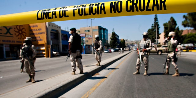 Mexican army soldiers guard the perimeter around the regional Attorney General's office after the early morning arrest of former Tijuana Mayor Jorge Hank Rohn in the city of Tijuana, Mexico, Saturday June 4, 2011. Hank Rhon, one of Mexico's most flamboyant businessmen and politicians, has been detained on suspicion of illegal weapons possession, the federal Attorney General's Office has announced. (AP Photo/Francisco Vega)