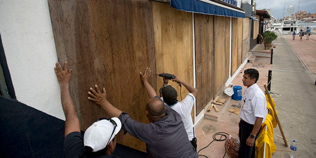 Workers board over a store front in preparation for Hurricane Newton, in Cabo San Lucas, Mexico, Monday Sept. 5, 2016. Authorities at the southern end of Mexico's Baja California peninsula ordered schools closed and set up emergency shelters as Hurricane Newton gained strength while bearing down on the twin resorts of Los Cabos for a predicted arrival Tuesday morning. (AP Photo/Eduardo Verdugo)