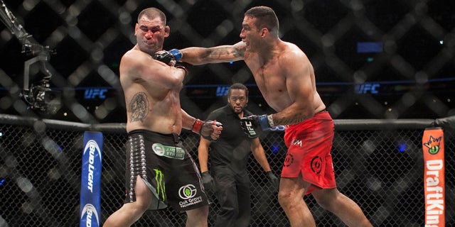 Brazil's Fabricio Werdum lands a punch to United States' Cain Velasquez during a heavyweight mixed martial arts title bout at UFC 188 in Mexico City, Saturday, June 13, 2015. Werdum won the fight by submission. (AP Photo/Christian Palma)