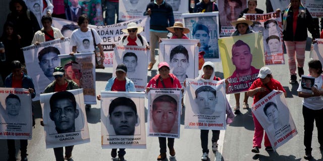 FILE - In this Jan. 26, 2015 file photo, relatives and protestors carry pictures of some of the 43 students who went missing in Sept. 26, 2014 from a rural teachers college in Guerrero state, during a march in Mexico City. Mexico has a serious problem with disappearances and lacks a comprehensive national list of the missing to effectively deal with the problem, according to a report the countrys National Human Rights Commission will present Monday, Feb. 2, 2015 to the U.N. (AP Photo/Eduardo Verdugo, File)