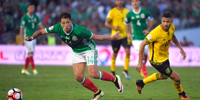 Mexico forward Chicharito, left, moves the ball as Jamaica midfielder Joel McAnuff pressures him during a Copa America group C soccer match at the Rose Bowl, Thursday, June 9, 2016, in Pasadena, Calif. (AP Photo/Mark J. Terrill)