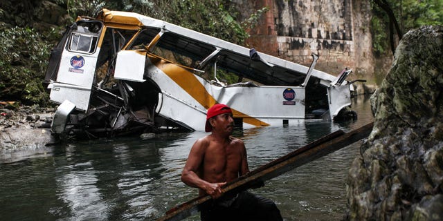 A passenger bus lays in a ravine after falling off the road in Atoyac, Veracruz state, Mexico, Sunday, Jan. 10, 2016. The bus, belonging to the Paso del Toro line, was carrying members of a football team and their relatives along the road connecting the cities of Camaron and Cordoba. According to authorities, at least 20 people were killed and 25 were injured. (AP Photo/Felix Marquez)