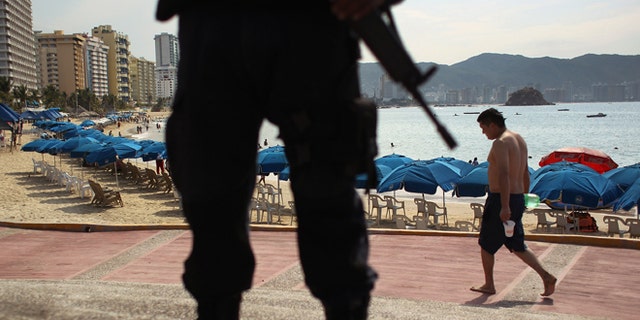 ACAPULCO, MEXICO - MARCH 04: A Mexican federal policeman stands guard near the beach on March 4, 2012 in Acapulco, Mexico. Drug violence has surged in the coastal resort in the last year, making Acapulco the second most deadly city in Mexico after Juarez. One of Mexico's top tourist destinations, Acapulco has suffered a drop in business, especially from foreign tourists, due to the violence. Toursim accounts for about 70 percent of the economy of Acapulco's state of Guerrero and 9 percent of Mexico's economy. (Photo by John Moore/Getty Images)