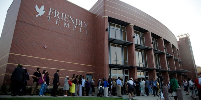 People begin to line up to attend the funeral for Michael Brown, Monday, Aug. 25, 2014, in St. Louis.