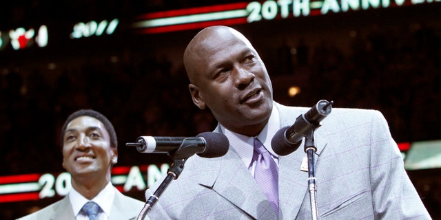 Former Bulls star Michael Jordan (R) talks to the crowd while Scottie Pippen looks on during a ceremony to honor the 20th anniversary of their first world championship at half time of the NBA basketball game between the Utah Jazz and Chicago Bulls in Chicago, Illinois March 12, 2011.