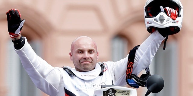 In this Sunday, Jan. 4 photo, Michal Hernik of Poland posses for a picture as he crosses the podium ramp during the symbolic start of the Dakar Rally 2015 in Buenos Aires, Argentina, 2015. According to race authorities Hernik was found dead during the third stage of the race between the cities of San Juan and Chilecito, in Argentina, Tuesday Jan. 6, 2015.