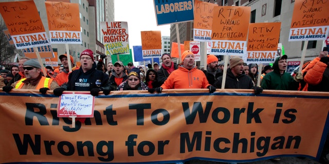 FILE: Dec. 11, 2012: Union members and supporters march to the Michigan State Capitol to protest against right-to-work legislation, in Lansing, Mich.