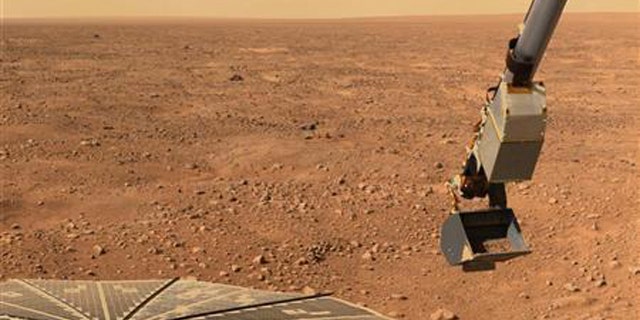 NASA's Phoenix Mars Landers solar panel and the lander's Robotic Arm with a sample in the scoop are seen in this image taken June 10, 2008, by the lander's Surface Stereo Imager.