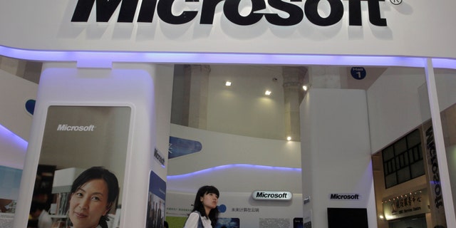 A visitor walks past a Microsoft booth at a computer software expo in Beijing, June 2, 2010. Microsoft Corp appears to be the latest U.S. company targeted by China for anti-trust investigation after government officials paid sudden visits to the software firm's Chinese offices on July 28, 2014. Picture taken June 2, 2010. REUTERS/Stringer (CHINA - Tags: BUSINESS SCIENCE TECHNOLOGY POLITICS) CHINA OUT. NO COMMERCIAL OR EDITORIAL SALES IN CHINA - RTR40GLI