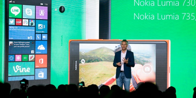 Chris Weber, CVP, Mobile Devices Sales of Microsoft presents the new Lumia 730 and 735 smart phones during his keynote speech at a Microsoft Nokia presentation event at the consumer electronic fair IFA in Berlin, Thursday, Sept. 4, 2014. (AP Photo/Markus Schreiber)
